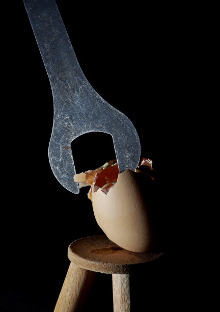 黑背景下的破鸡蛋和扳手图片下载