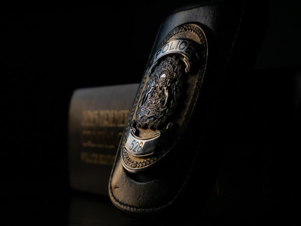 一个警察徽章靠在刑法文件上的特写镜头图片下载