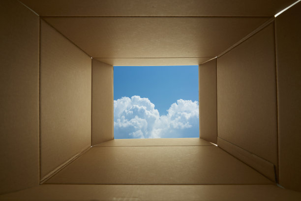 透过纸板箱向蓝色的天空背景看。图片下载