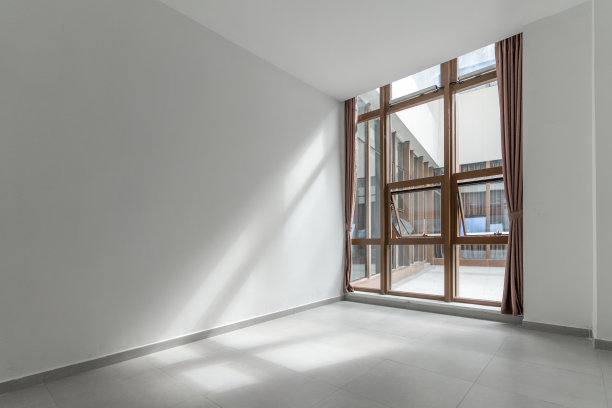 阳光透过玻璃窗照进空荡荡的白色房间图片下载