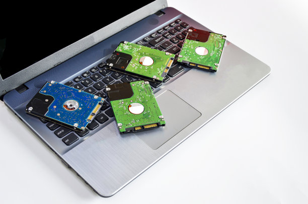 2.5英寸硬盘转盘放在笔记本电脑的白色屏幕后面图片下载