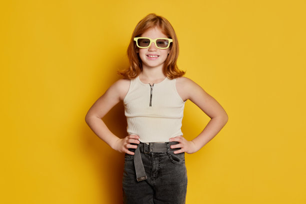 时装模特儿。快乐的小女孩，红色长发和雀斑戴着太阳镜，隔离在明亮的黄色背景。情感的概念，夏天的心情，音乐，幸福图片下载