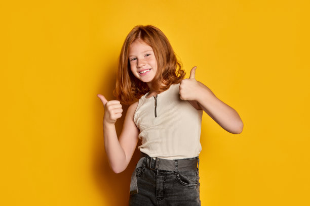 好,好。小女孩的肖像，红色长发和雀斑隔离在明亮的黄色背景。概念儿童情感，舞蹈，音乐，幸福图片下载