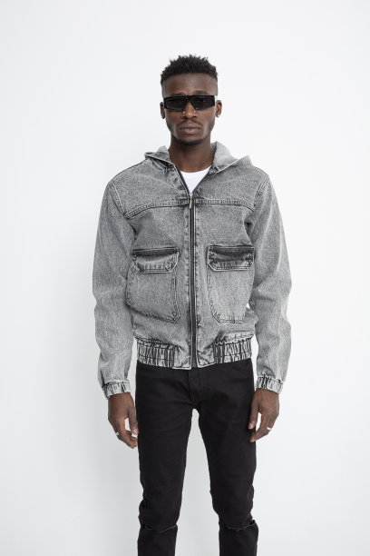 黑人男模特戴着墨镜，穿着牛仔夹克，站在白色背景前。图片下载