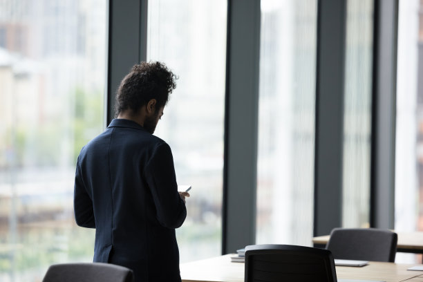 后视图商人使用现代设备站在办公室会议室图片下载