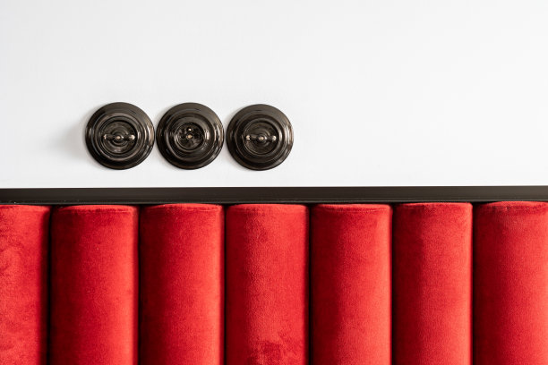 插座和电灯开关安装在床床头板上方的墙上图片下载