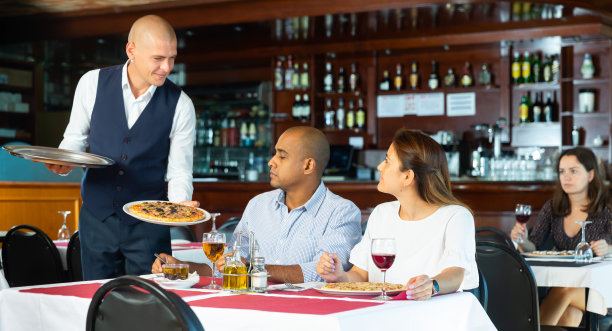 友好的服务员带来订购的披萨夫妇在披萨店图片下载