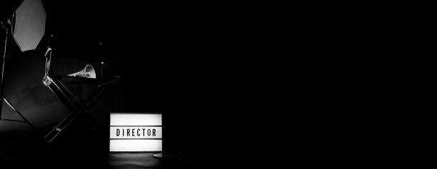 导演椅与影院灯箱标志导演文字在它和隔板扩音器和黑色背景工作室。电影工业用的录像制作或拍摄设备上的导演座位。真实没有3D图片下载