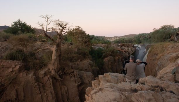 徒步旅行者在悬崖边上给猴面包树拍照图片下载