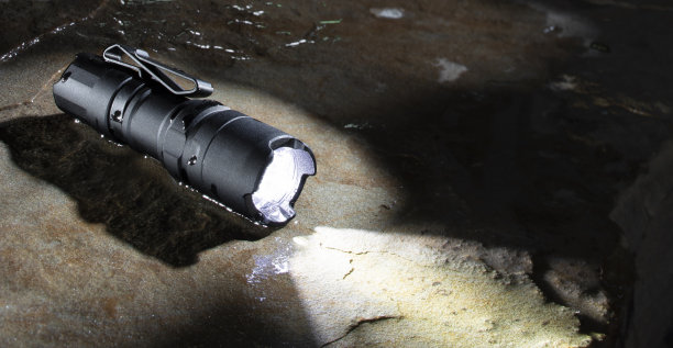防水手电筒放在潮湿的岩石上图片下载