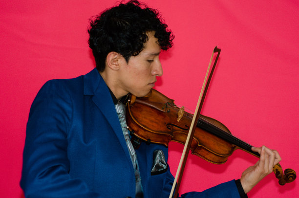 在彩色背景上拉小提琴的男子图片下载