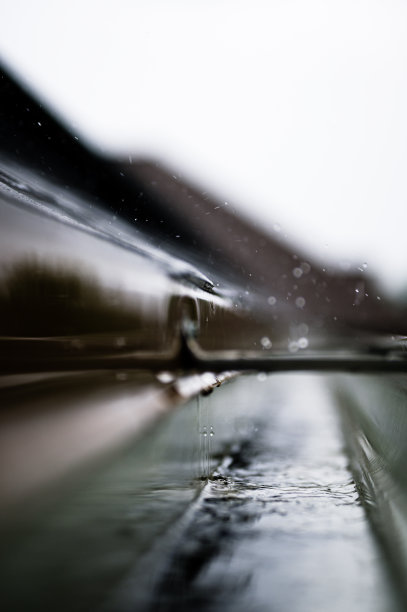 有选择地集中在一段住宅排水沟与吊架输送水在暴雨期间。可见雨点和雨滴。图片下载