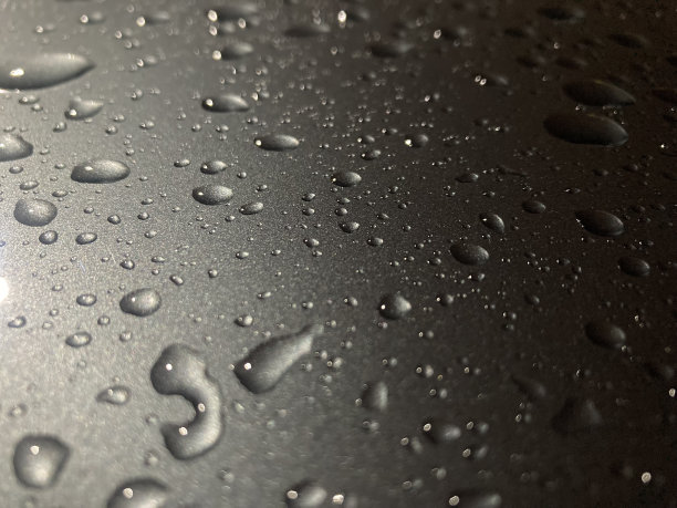 傍晚金属表面雨滴的微距镜头图片下载