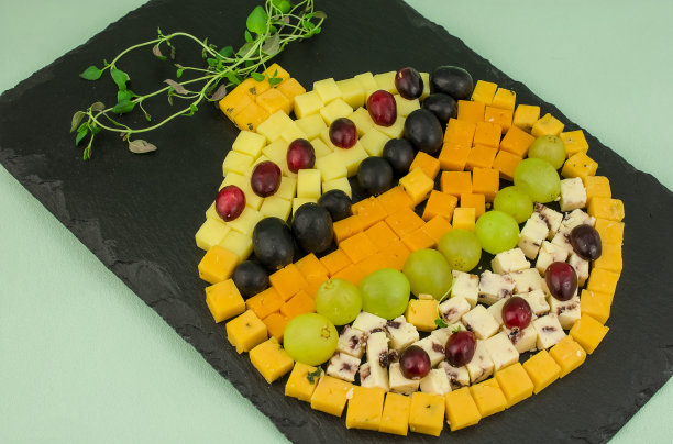 各种奶酪和葡萄放在黑板上图片下载