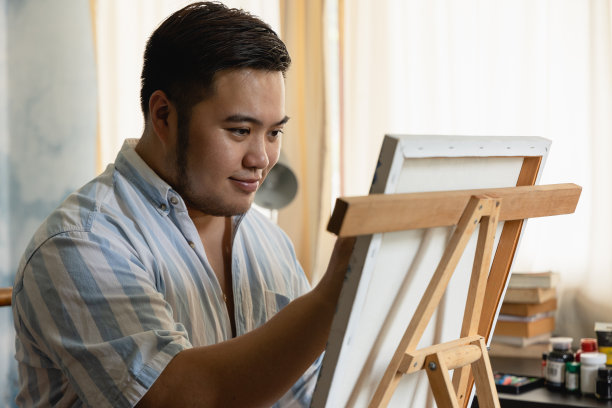 年轻的艺术家在画布前创作或绘画图片下载