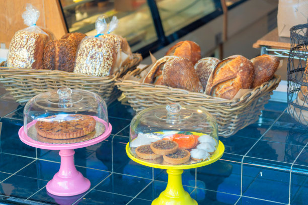 糕饼和面包摆放在面包店的窗户上，还有纸杯蛋糕、松饼和其他零食图片下载