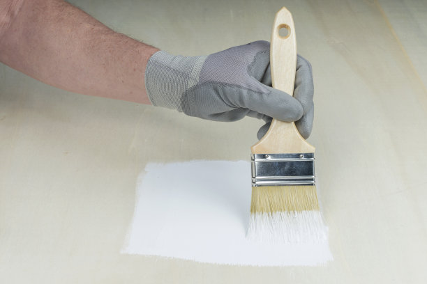 男手用刷子在木头上刷底漆。DIY的概念。图片下载