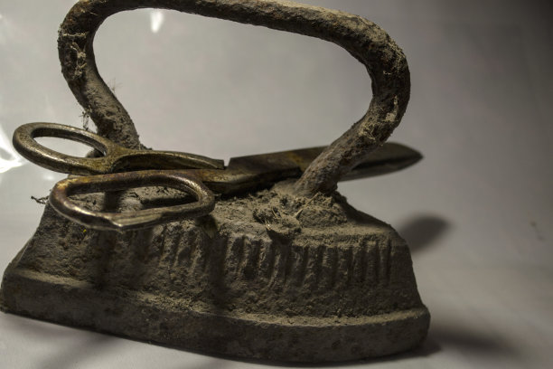 又大又湿的剪刀和在炉子上加热过的古董熨斗。图片下载