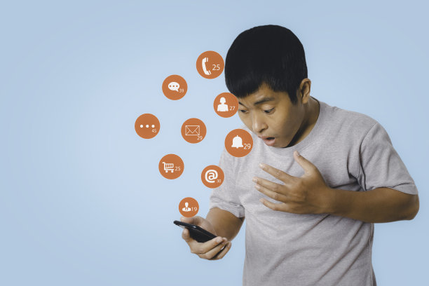 手机上的社交媒体和数字在线。一名男子使用智能手机与社交媒体图标震惊和惊喜。图片下载