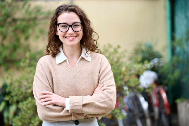 年轻快乐微笑的职业商业女性站在户外，画像。图片下载