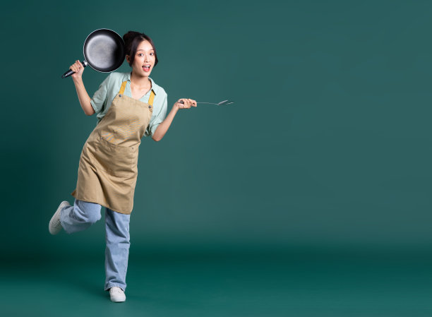 穿着围裙拿着平底锅的亚洲妇女图片下载
