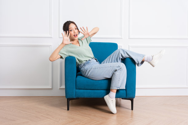 年轻的亚洲女孩坐在家里的沙发上的形象图片下载