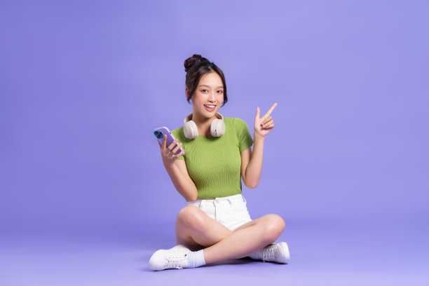 美丽的亚洲女孩在粉色背景上摆姿势的全身图像图片下载