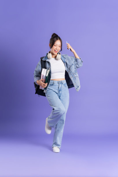 一个美丽的亚洲女学生穿着紫色背景背包的肖像图片下载