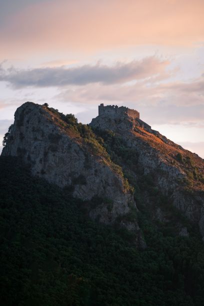 日落时山顶岩石的垂直照片图片下载
