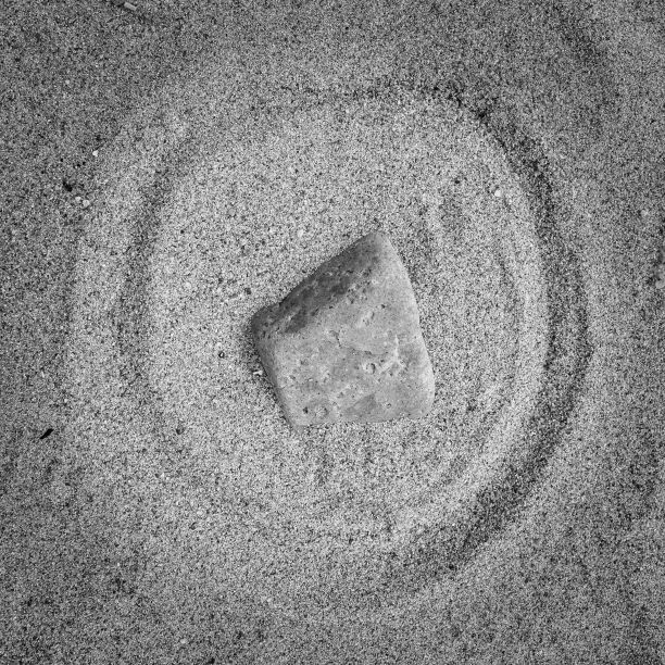 沙滩上的石头的灰度照片图片下载