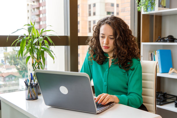 一个女人在窗前写笔记本图片下载