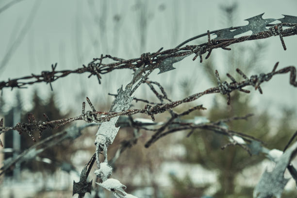 旧铁丝网上的混凝土栅栏在冬天的雪大特写选择性聚焦图片下载