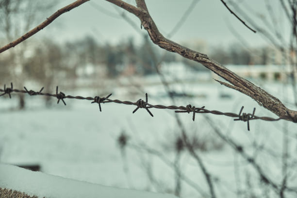 旧铁丝网上的混凝土栅栏在冬天的雪大特写选择性聚焦图片下载