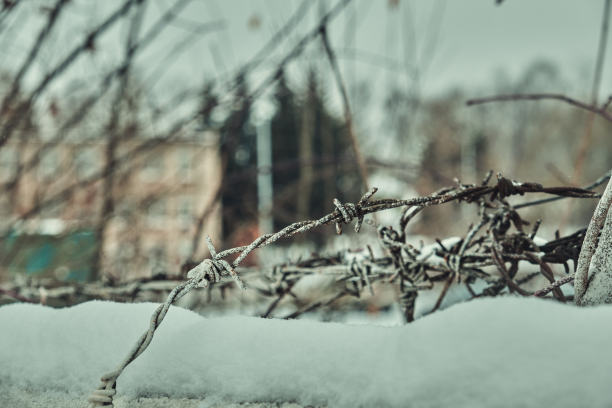 旧铁丝网上的混凝土栅栏在冬天的雪大特写选择性聚焦图片下载