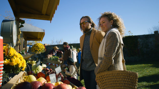 一对夫妇站在水果和蔬菜的摊位上图片下载