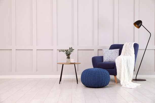 时尚的房间内部，舒适的扶手椅和针织蒲团附近的白墙图片下载