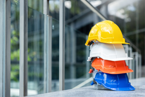 建筑工人，工程师，技术人员，在建筑工地工作的检查员的头盔。工作时戴安全安全帽，防止事故发生。蓝领的工作设备图片下载