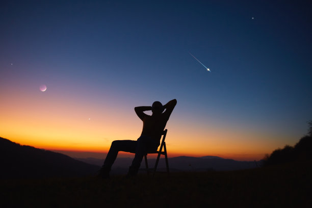 人类看着夜空，星星，行星，月亮和流星。图片下载