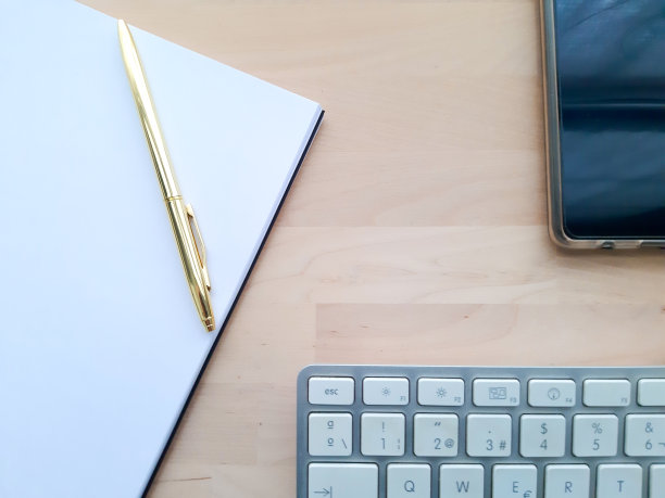 办公桌配有办公配件，办公器物放在木桌上。

居家办公办公桌办公室，电脑，智能手机，白色和金色的钢笔在木桌上图片下载