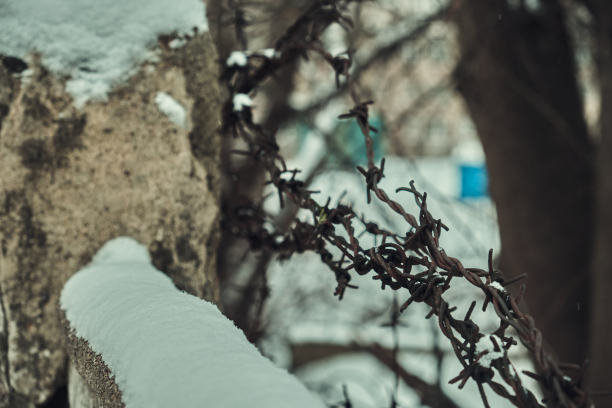 混凝土栅栏上的旧铁丝网，冬天的雪很大特写选择性聚焦图片下载