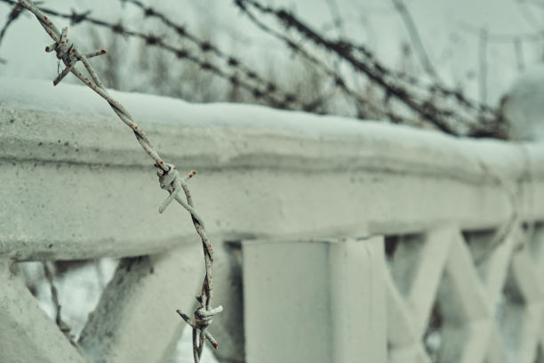 混凝土栅栏上的旧铁丝网，冬天的雪很大特写选择性聚焦图片下载