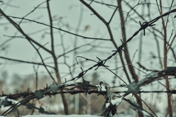 混凝土栅栏上的旧铁丝网，冬天的雪很大特写选择性聚焦图片下载