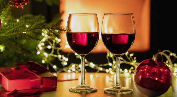 餐桌上有红酒和圣诞装饰，壁炉背景。圣诞节的庆祝活动图片下载