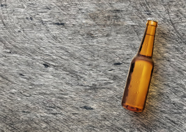 啤酒瓶在木板草坪上的特写。俯视图图片下载