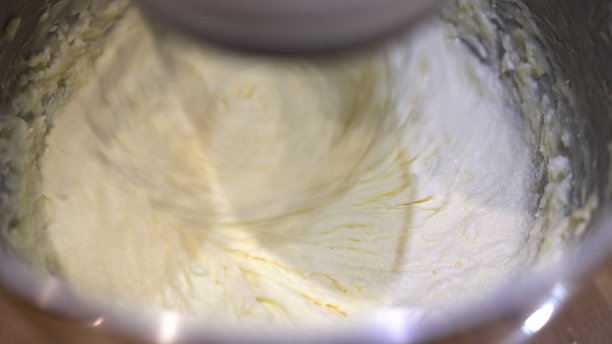 行星搅拌机为烹饪产品近距离搅拌奶油。厨房自动搅拌机。图片下载