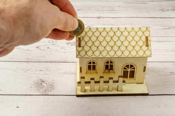 迷你木屋和手工引进的欧元硬币。购房储蓄概念。抵押贷款利率上升图片下载