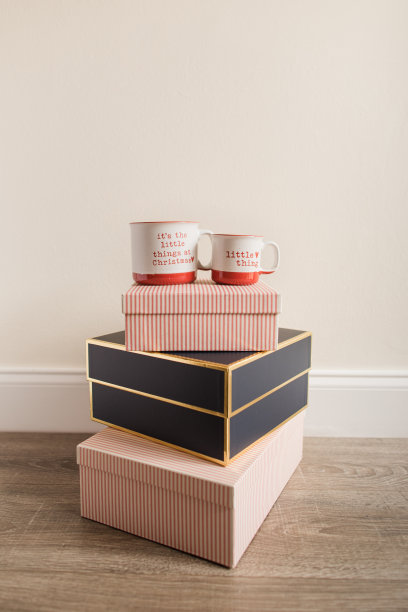 一套可爱的红色和白色热可可马克杯，上面写着“圣诞节的小事情”和“小事情”，放在红白条纹的圣诞礼物上图片下载