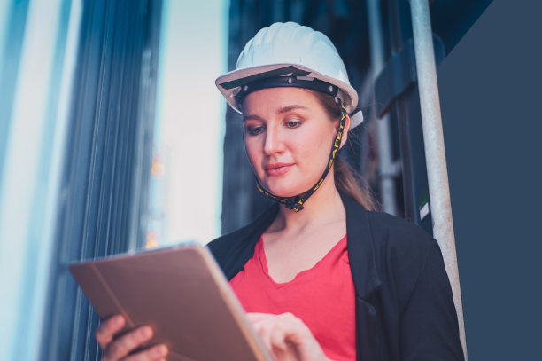 集装箱出口业务经理站在集装箱堆场检查，女业务员在集装箱装货码头后勤运输管理图片下载