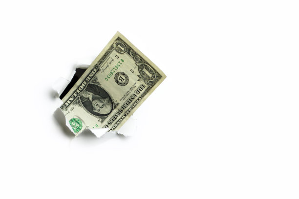 一美元从白色背景的一个洞里伸出来，这是不完整的收入。图片下载