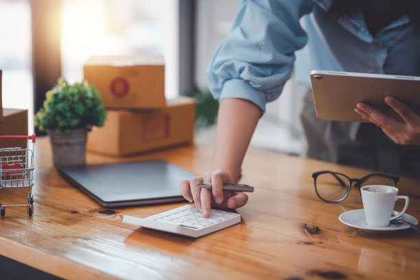 企业主在办公室用手持平板电脑按下计算器。图片下载